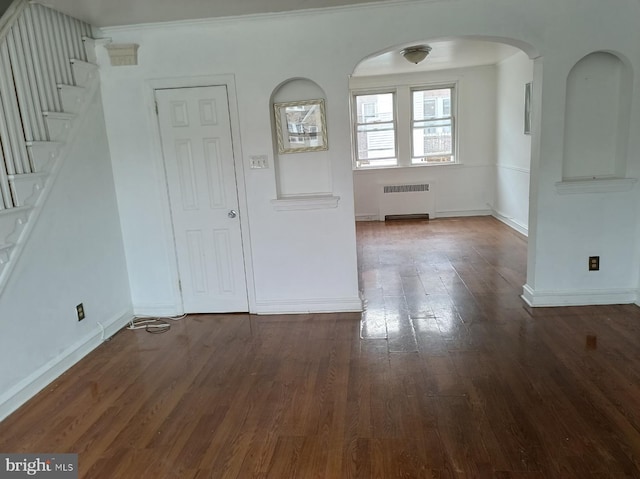 1420 Magee Ave, Philadelphia, PA 19111 - spare room featuring radiator heating unit, wood finished floors, arched walkways, stairs, and ornamental molding