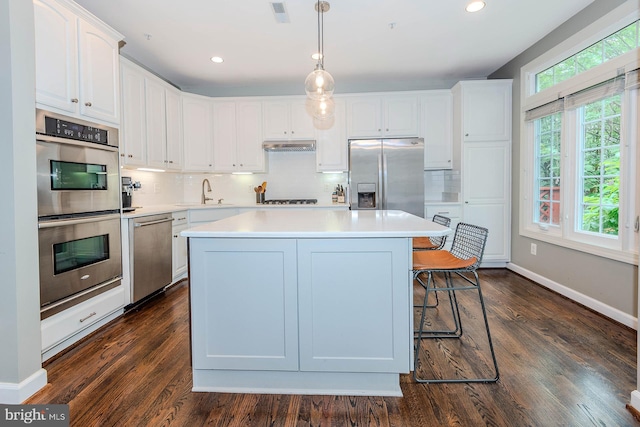 712 Arch Hall Ln, Alexandria, VA 22314 - kitchen featuring stainless steel appliances, white cabinetry, a kitchen island, tasteful backsplash, and light countertops