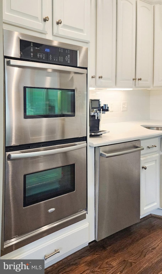 712 Arch Hall Ln, Alexandria, VA 22314 - kitchen with appliances with stainless steel finishes, white cabinetry, dark wood-style flooring, and light countertops