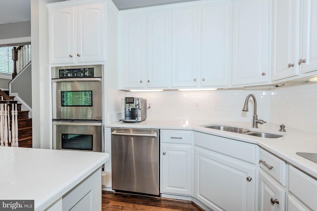 712 Arch Hall Ln, Alexandria, VA 22314 - kitchen featuring appliances with stainless steel finishes, tasteful backsplash, light countertops, dark wood finished floors, and white cabinetry