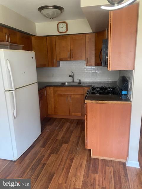 3720 Conshohocken Ave, Philadelphia, PA 19131 - kitchen featuring freestanding refrigerator, brown cabinets, dark wood-style flooring, and dark countertops