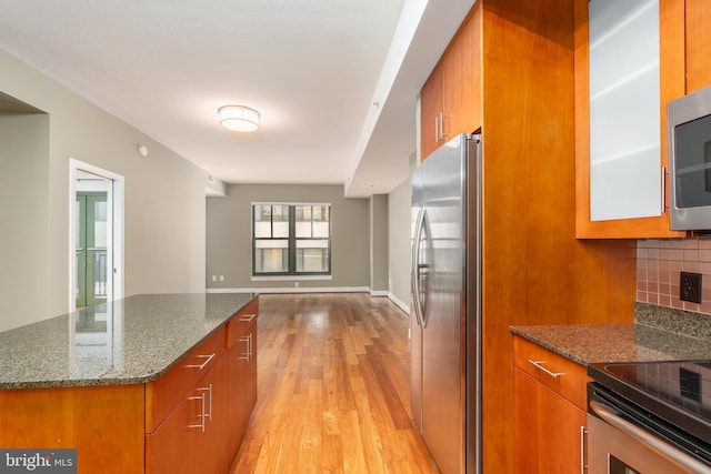 910 M St NW Unit 708, Washington, DC 20001 - kitchen featuring appliances with stainless steel finishes, brown cabinetry, and light wood-type flooring