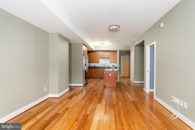 910 M St NW Unit 708, Washington, DC 20001 - kitchen with stainless steel refrigerator with ice dispenser, backsplash, light wood-type flooring, and brown cabinetry