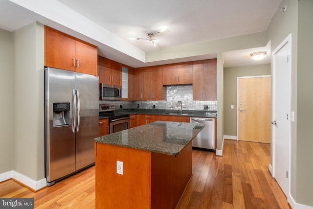 910 M St NW Unit 708, Washington, DC 20001 - kitchen featuring appliances with stainless steel finishes, tasteful backsplash, brown cabinets, and light wood-style flooring