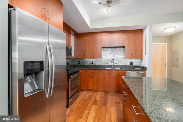 910 M St NW Unit 708, Washington, DC 20001 - kitchen featuring stainless steel appliances, brown cabinets, light wood-type flooring, electric panel, and decorative backsplash