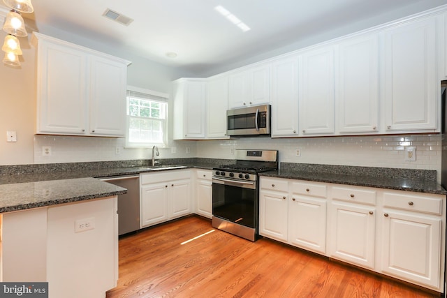 2066 Capstone Cir, Herndon, VA 20170 - kitchen featuring appliances with stainless steel finishes, white cabinetry, light wood finished floors, and backsplash