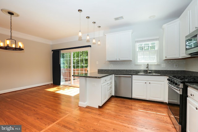 2066 Capstone Cir, Herndon, VA 20170 - kitchen featuring stainless steel appliances, a peninsula, healthy amount of natural light, a chandelier, and ornamental molding
