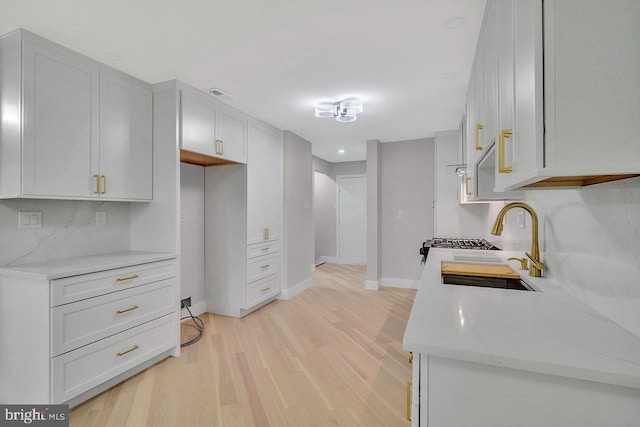 166 Neil Ct, Princeton, NJ 08540 - kitchen with backsplash, light wood-style floors, light stone counters, and white cabinetry