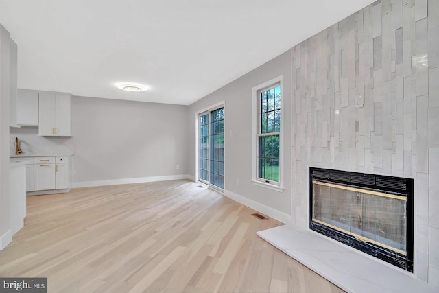 166 Neil Ct, Princeton, NJ 08540 - unfurnished living room with a glass covered fireplace and light wood-type flooring