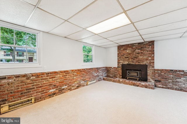 4376 Rock Ct, Waldorf, MD 20602 - unfurnished living room featuring a wood stove, brick wall, carpet floors, and a drop ceiling