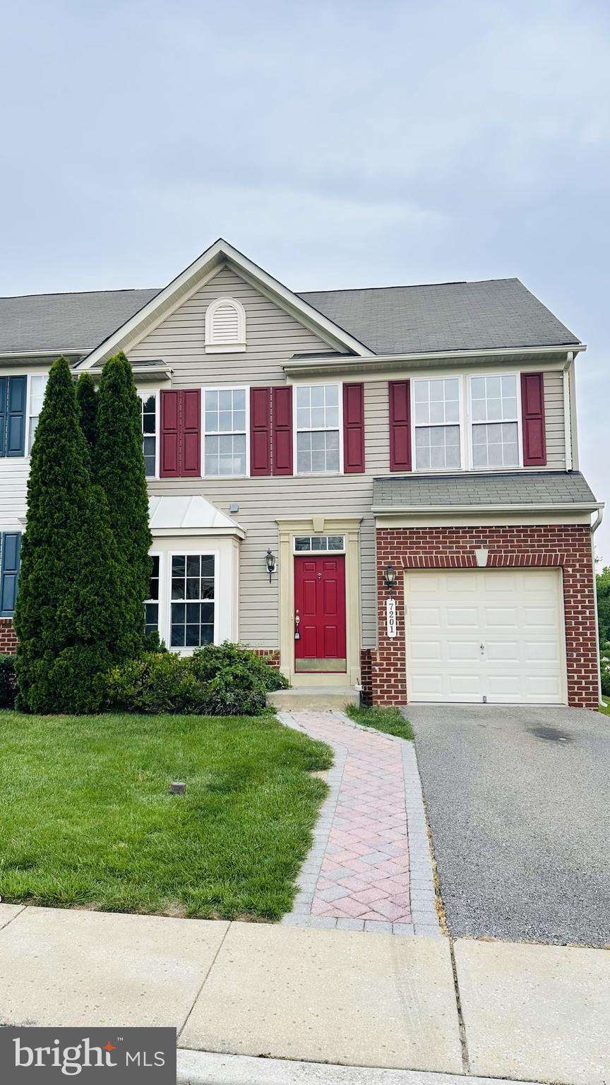 7201 Torpoint Ct, Hanover, MD 21076 - view of property with asphalt driveway, an attached garage, a front lawn, and brick siding
