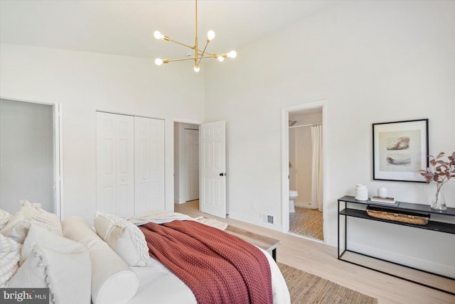 3402 Stevenswood Ct, Baltimore, MD 21244 - bedroom featuring a chandelier, a towering ceiling, light wood-style floors, connected bathroom, and a closet