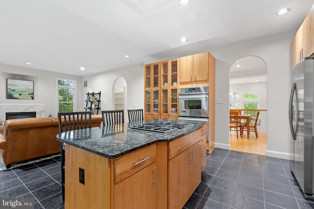 3929 Vacation Ln, Arlington, VA 22207 - kitchen featuring stainless steel appliances, arched walkways, recessed lighting, dark tile patterned floors, and a center island