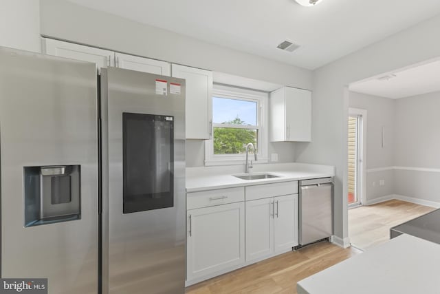 8995 Patterson Pl, Manassas, VA 20110 - kitchen with stainless steel appliances, light wood-style flooring, white cabinets, and light countertops