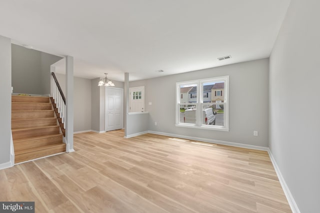 8995 Patterson Pl, Manassas, VA 20110 - unfurnished living room with a chandelier, stairs, and light wood finished floors