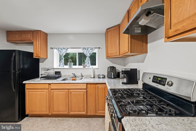 3519 Sunset Ave, Williamstown, NJ 08094 - kitchen featuring stainless steel range with gas cooktop, exhaust hood, freestanding refrigerator, and brown cabinets