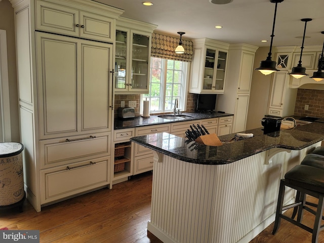 2424 Stanwick Rd, Phoenix, MD 21131 - kitchen featuring cream cabinets, backsplash, dark wood-style floors, a breakfast bar area, and recessed lighting