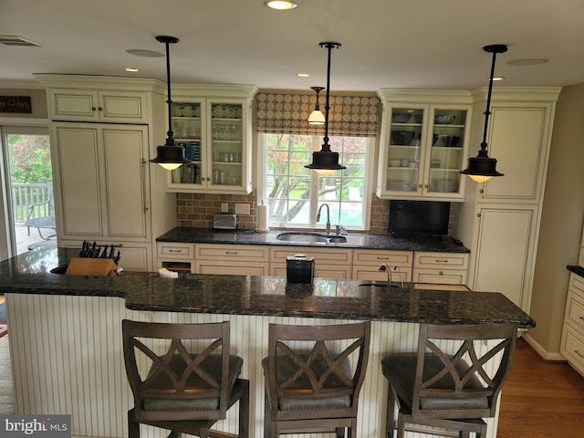 2424 Stanwick Rd, Phoenix, MD 21131 - kitchen featuring cream cabinets, decorative backsplash, glass insert cabinets, hanging light fixtures, and recessed lighting
