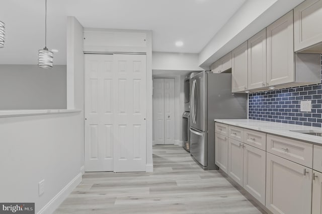 2 Stonehenge Cir Unit 2A-2, Baltimore, MD 21208 - kitchen featuring stacked washing machine and dryer, tasteful backsplash, freestanding refrigerator, light wood-style floors, and recessed lighting