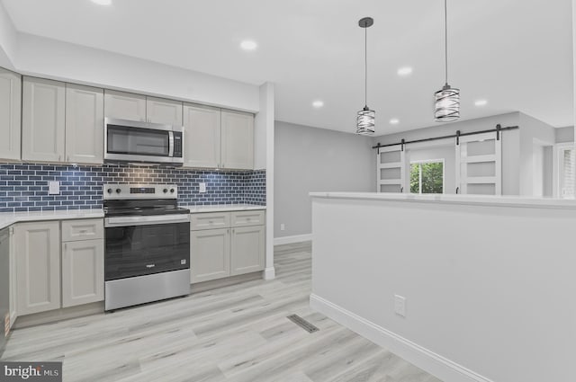 2 Stonehenge Cir Unit 2A-2, Baltimore, MD 21208 - kitchen with appliances with stainless steel finishes, a barn door, recessed lighting, backsplash, and light countertops