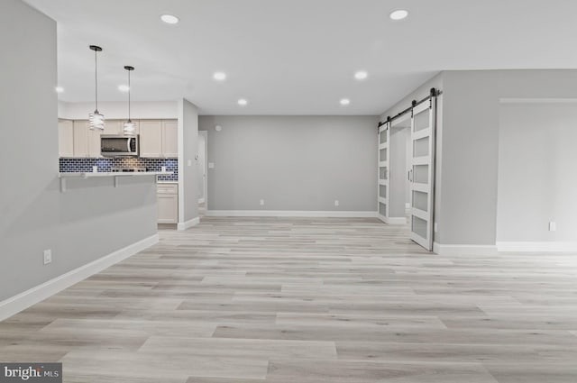 2 Stonehenge Cir Unit 2A-2, Baltimore, MD 21208 - unfurnished living room with recessed lighting, a barn door, and light wood-style floors