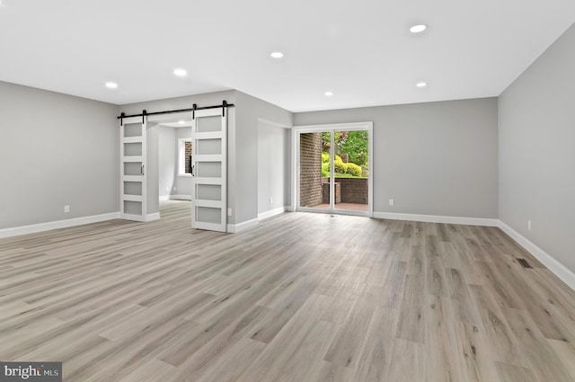 2 Stonehenge Cir Unit 2A-2, Baltimore, MD 21208 - unfurnished living room with a barn door, recessed lighting, and light wood finished floors
