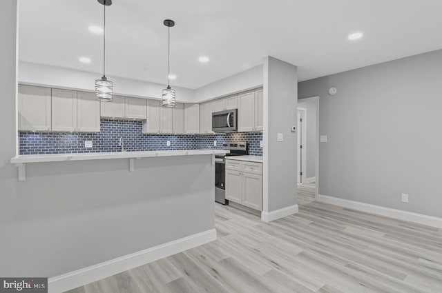 2 Stonehenge Cir Unit 2A-2, Baltimore, MD 21208 - kitchen featuring stainless steel appliances, light countertops, tasteful backsplash, a breakfast bar, and recessed lighting