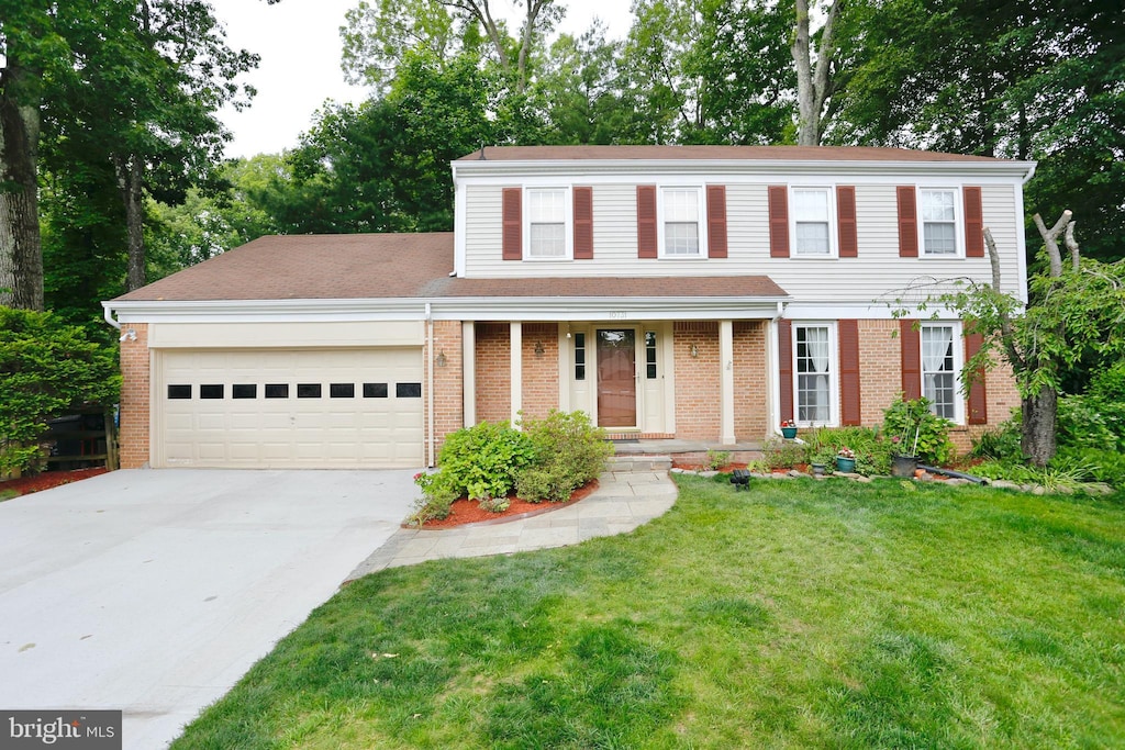 10731 Bear Oak Ct, Burke, VA 22015 - view of front of home with a garage, concrete driveway, brick siding, and a front lawn