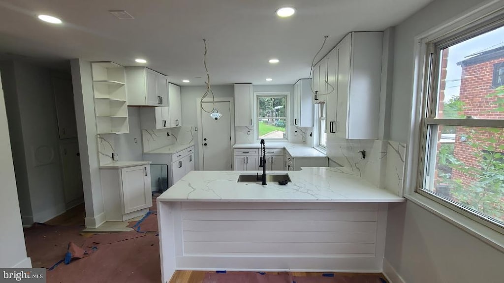 5155 8th St NE, Washington, DC 20011 - kitchen with a peninsula, light stone countertops, backsplash, recessed lighting, and white cabinets