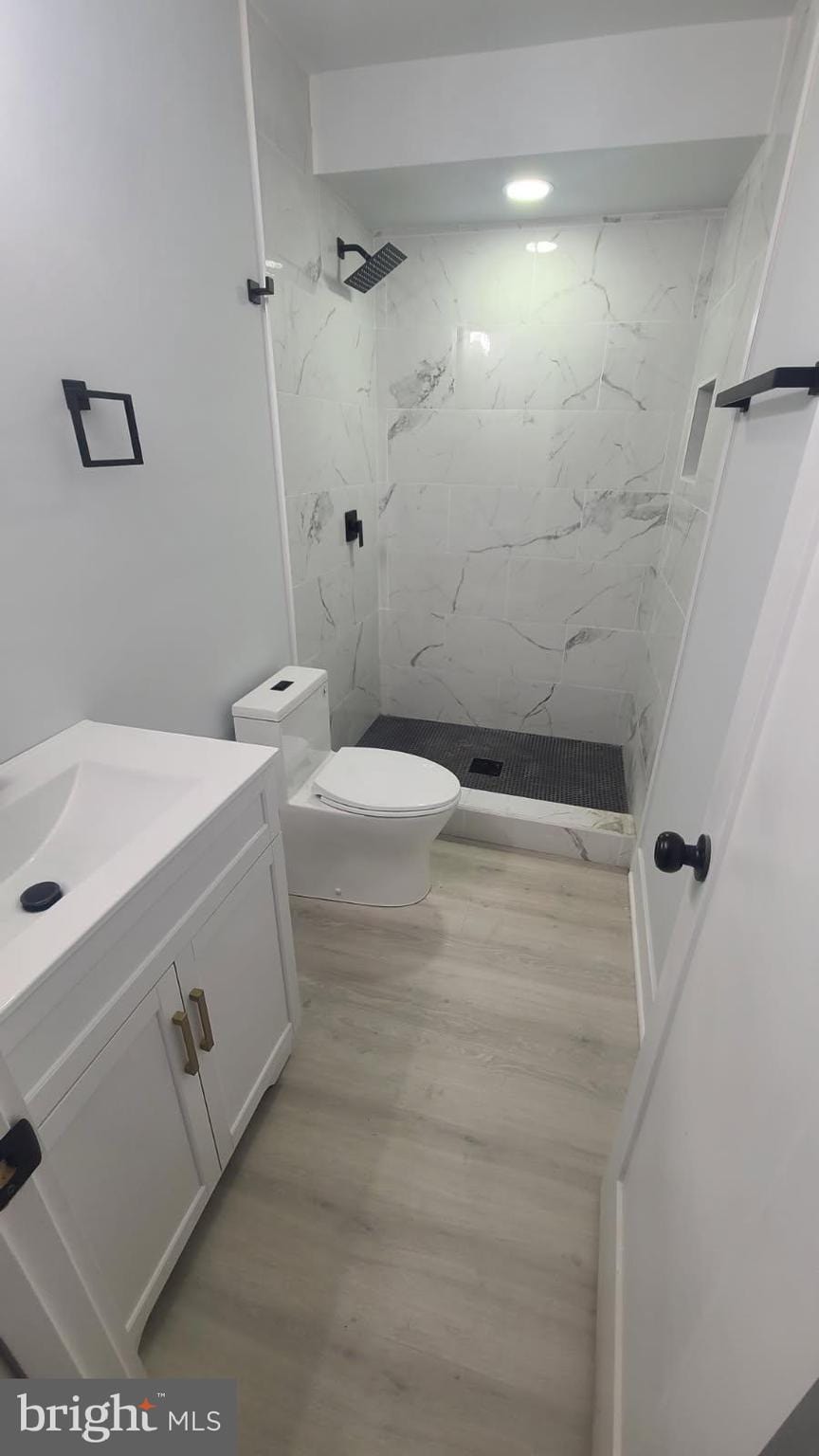5155 8th St NE, Washington, DC 20011 - bathroom featuring vanity, a marble finish shower, and wood finished floors