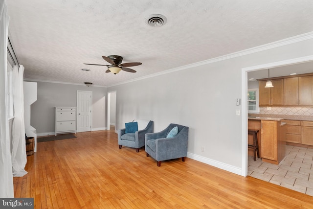 5379 Payne Dr, King George, VA 22485 - living area with ceiling fan, light wood finished floors, ornamental molding, and a textured ceiling