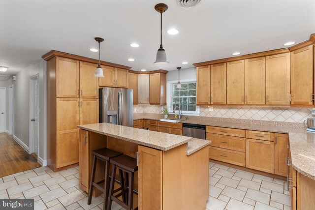 5379 Payne Dr, King George, VA 22485 - kitchen featuring stainless steel appliances, a center island, tasteful backsplash, light stone counters, and recessed lighting