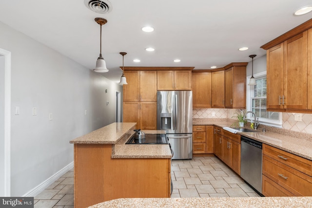 5379 Payne Dr, King George, VA 22485 - kitchen with stainless steel appliances, a kitchen island, tasteful backsplash, brown cabinets, and recessed lighting