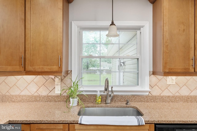 5379 Payne Dr, King George, VA 22485 - kitchen with tasteful backsplash, black dishwasher, brown cabinetry, decorative light fixtures, and light stone counters