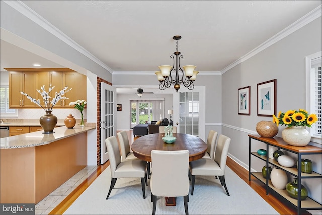 5379 Payne Dr, King George, VA 22485 - dining room featuring french doors, crown molding, light wood-style flooring, a chandelier, and ceiling fan