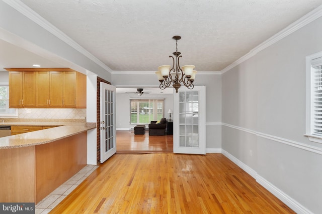 5379 Payne Dr, King George, VA 22485 - unfurnished dining area with light wood-style flooring, a chandelier, a textured ceiling, french doors, and crown molding