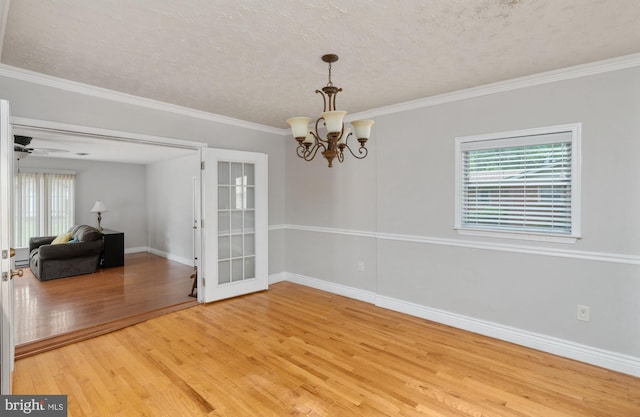 5379 Payne Dr, King George, VA 22485 - spare room featuring light wood-type flooring, healthy amount of natural light, a textured ceiling, a chandelier, and ornamental molding