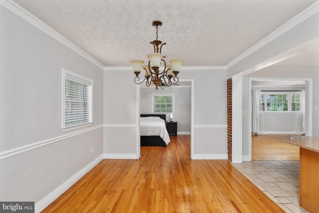 5379 Payne Dr, King George, VA 22485 - unfurnished dining area featuring healthy amount of natural light, a chandelier, light wood-type flooring, a textured ceiling, and ornamental molding