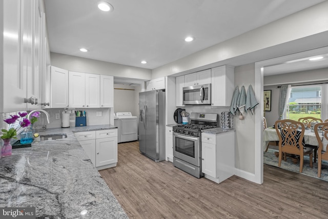 31 Mercator Ln, Willingboro, NJ 08046 - kitchen featuring stainless steel appliances, washer / clothes dryer, white cabinetry, light wood-style flooring, and light stone counters