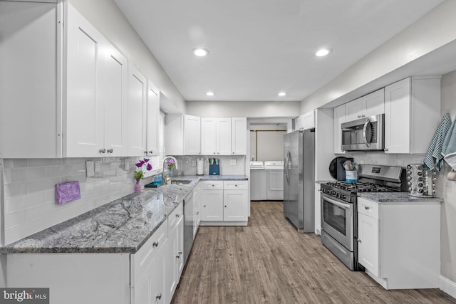 31 Mercator Ln, Willingboro, NJ 08046 - kitchen with stainless steel appliances, washing machine and dryer, light wood-style flooring, tasteful backsplash, and recessed lighting