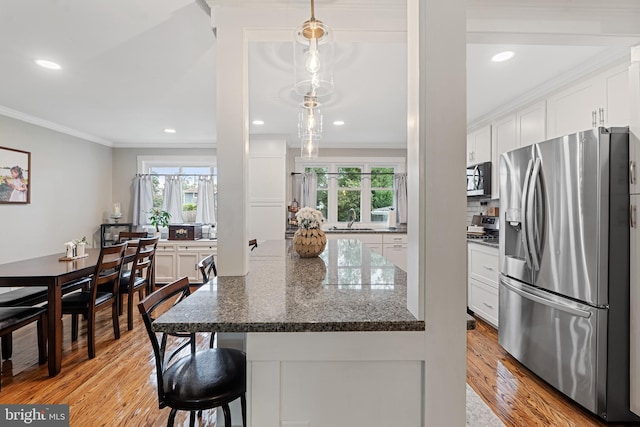 202 E Franklin Ave, Edgewater Park, NJ 08010 - kitchen with appliances with stainless steel finishes, crown molding, healthy amount of natural light, white cabinets, and light wood-type flooring