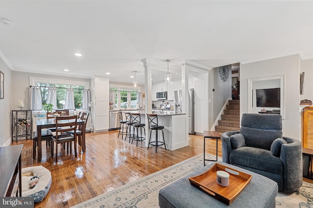 202 E Franklin Ave, Edgewater Park, NJ 08010 - living room with crown molding, light wood-style flooring, ornate columns, stairs, and recessed lighting