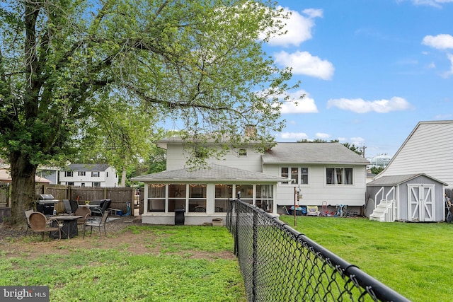202 E Franklin Ave, Edgewater Park, NJ 08010 - rear view of house with a sunroom, a storage unit, a fenced backyard, roof with shingles, and a chimney