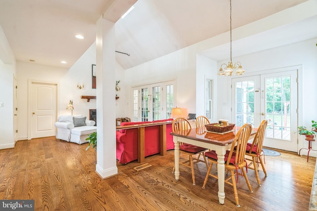 580 Buchanon Rd, Honey Brook, PA 19344 - dining area featuring wood finished floors, lofted ceiling, french doors, a glass covered fireplace, and a chandelier