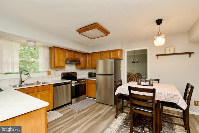 8225 Triple Crown Rd, Bowie, MD 20715 - kitchen with appliances with stainless steel finishes, under cabinet range hood, light wood finished floors, light countertops, and backsplash
