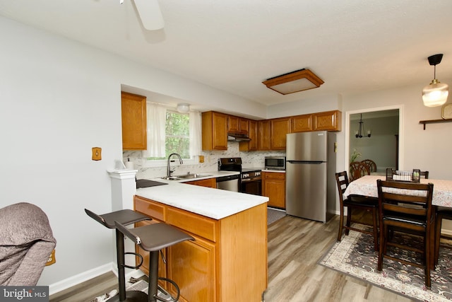 8225 Triple Crown Rd, Bowie, MD 20715 - kitchen featuring stainless steel appliances, light countertops, under cabinet range hood, and light wood-type flooring
