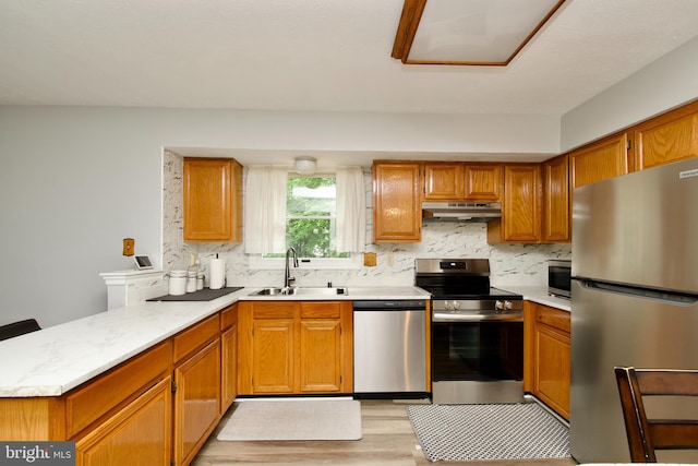 8225 Triple Crown Rd, Bowie, MD 20715 - kitchen featuring stainless steel appliances, a peninsula, under cabinet range hood, light countertops, and backsplash