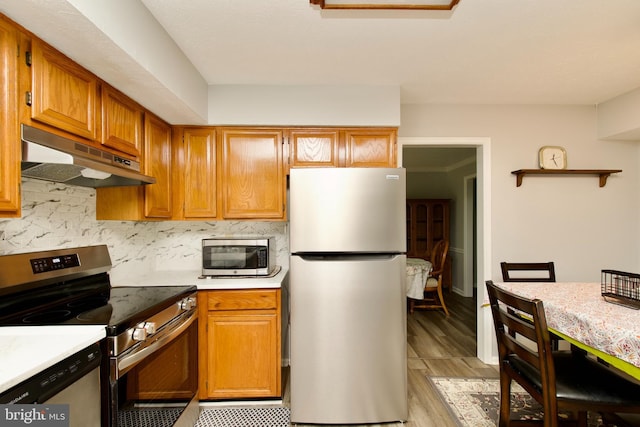 8225 Triple Crown Rd, Bowie, MD 20715 - kitchen featuring appliances with stainless steel finishes, under cabinet range hood, light countertops, and light wood finished floors