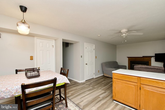 8225 Triple Crown Rd, Bowie, MD 20715 - dining space with ceiling fan, light wood-style floors, and a fireplace