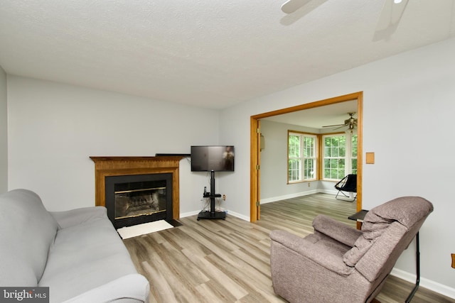 8225 Triple Crown Rd, Bowie, MD 20715 - living area with a ceiling fan, wood finished floors, a fireplace with flush hearth, and a textured ceiling